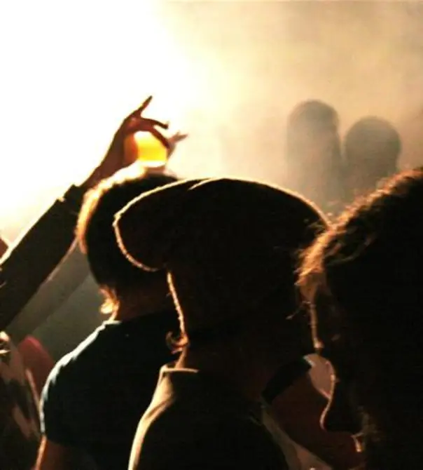 A crowd of people standing around in the dark.