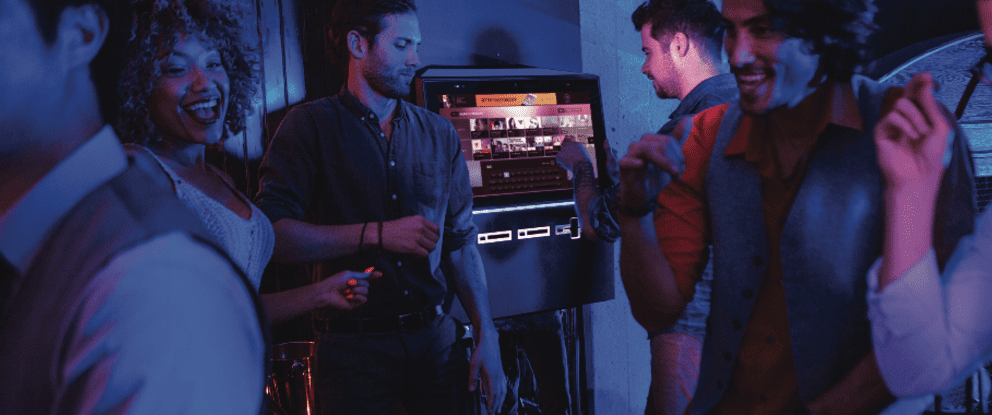 Two men standing in front of a large tv.